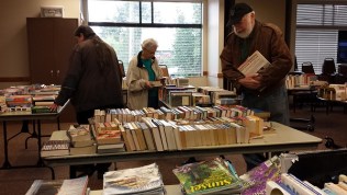 People browse the annual book sale for the Writers in the Grove.